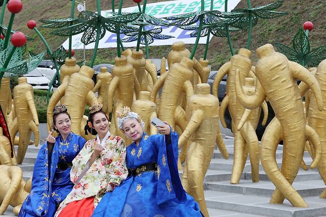 19일 충남 금산세계인삼엑스포광장에서 방문객들이 인삼 조형물 앞에 앉아 기념 촬영하고 있다./뉴스1
