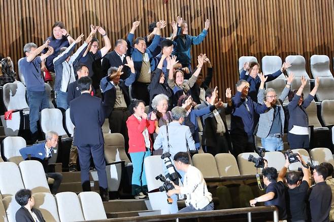 25일 서울 여의도 국회에서 열린 본회의에서 경북·경남·울산 초대형산불 피해구제 및 지원 등을 위한 특별법안이 통과되자 피해 주민들이 기뻐하고 있다. 연합뉴스