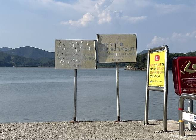 여수시 화양면 오천리 갯벌 일대. 어촌계 경고판(가운데 2개)은 불법 어업과 쓰레기 투기 금지를 설명하고 있으며, 여수시 경고판(오른쪽 1개)은 해상데크 진입이 불가한 교통수단을 안내하고 있다. 녹색연합 해양환경기록단