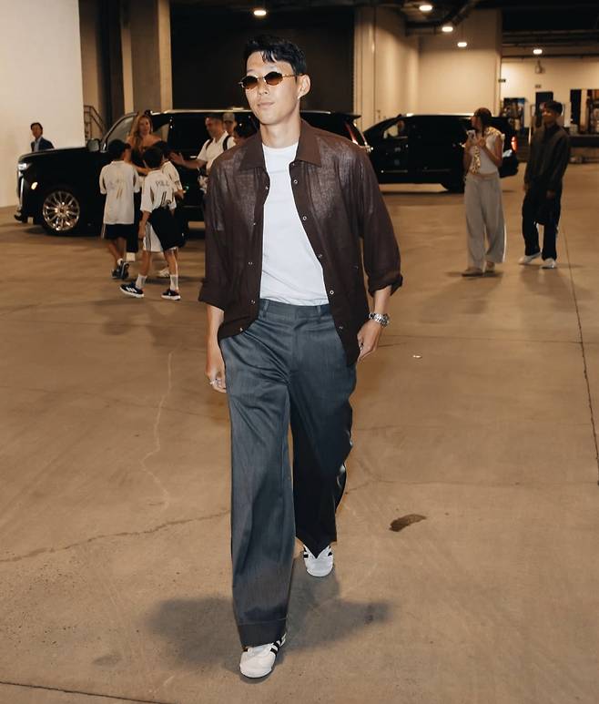 손흥민이 9월 1일(한국시간) 샌디에이고 FC와 MLS 홈 데뷔전을 치르기 위해 홈구장인 BMO 스타디움에 입장하는 모습. 이날 손흥민은 갈색 셔츠에 밑단이 롤업된 회색 와이드 슬랙스를 입었다. 금색 테에 갈색 알이 들어간 선글라스를 포인트 아이템으로 활용했다. 이날 룩은 영국에서 뛸 때보다 미국에서 패션이 더 화려해졌다고 느끼게 하기 충분했다. 사진=LAFC