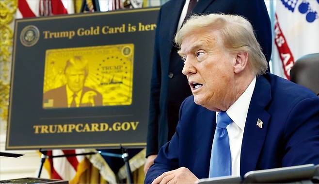 도널드 트럼프 미국 대통령이 지난 19일 전문직(H-1B) 비자 발급 수수료를 10만달러로 인상하고 100만달러를 내면 영주권을 받을 수 있는 ‘골드카드’ 신설 행정명령에 서명한 뒤 취재진 질문에 답하고 있다. 트럼프 대통령 옆에 골드카드 견본 이미지가 전시돼 있다. AP연합뉴스