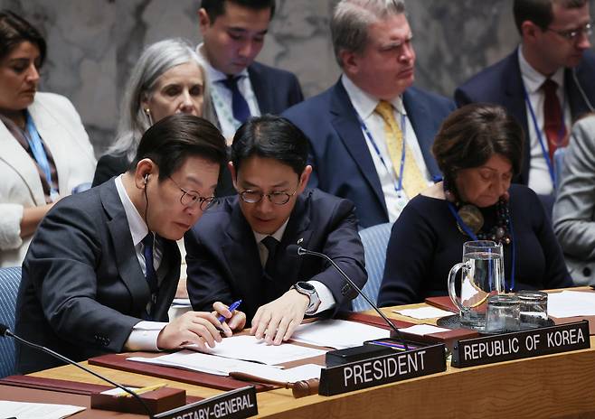 이재명 대통령이 24일(현지시간) 미국 뉴욕 유엔본부에서 안전보장이사회 공개토의를 주재하며 통역관과 대화하고 있다. 연합뉴스