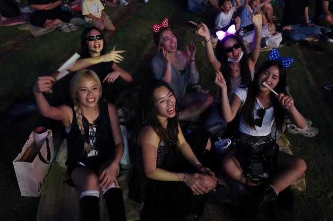 Tourists take part in a sing-along event for "KPop Demon Hunters" at Seoul Square on Sept. 14. (Yonhap)