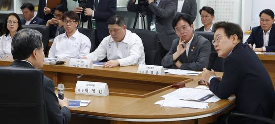 President Lee Jae Myung, right, speaks about industrial accidents with entrepreneurs and workers during a discussion session held at a baking factory in Gyeonggi on July 25. [JOINT PRESS CORPS]