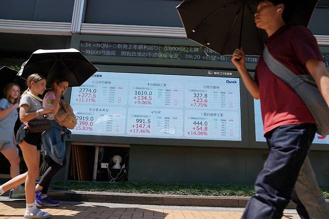 7월23일 일본 도쿄 증권거래소에 설치된 시세판 앞으로 사람들이 지나가고 있다./AFPBBNews=뉴스1