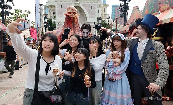 25일 오전 서울 송파구 롯데월드 어드벤처 매직아일랜드를 찾은 학생들이 롯데월드 호러 판타지 가을 시즌 축제 ‘스트리트 호러쇼: 더 마리오네트’ 연기자들과 함께 기념촬영을 하고 있다. 임세준 기자