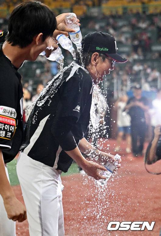 [OSEN=인천, 민경훈 기자] 25일 오후 인천 SSG랜더스필드에서 ‘2025 신한 SOL BANK KBO리그’ SSG 랜더스와 KT 위즈의 경기가 진행됐다.이 경기에서 KT는 SSG에 10-1 완승을 거두며 4연승을 질주했다. 3위 SSG를 잡은 5위 KT는 SSG를 1.5게임차로 맹추격했다. 4위 삼성도 키움전 승리를 거두면서 3위 경쟁은 결과를 예측할 수 없는 혼돈에 빠졌다.&nbsp;경기를 마치고 1000경기를 치른 KT 이강철 감독이 선수들에게 축하 물세례를 받고 있다. 2025.09.25 / rumi@osen.co.kr
