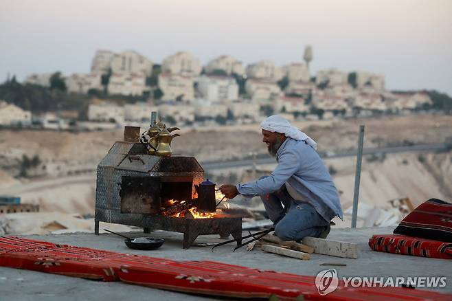 지난 9월 17일(현지시간) 요르단강 서안의 이스라엘 정착촌 앞에서 커피를 끓이는 팔레스타인 베두인족 남성 [로이터 연합뉴스 자료사진. 재판매 및 DB 금지]