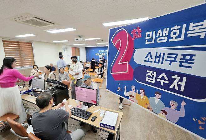 민생회복 소비쿠폰 2차 신청 첫날인 지난 22일 광주 북구 용봉동 행정복지센터에서 직원들이 주민들에게 소비쿠폰을 지급하고 있다. (사진=연합뉴스)