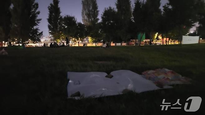 '2025 서울세계불꽃축제' 개최 전날인 26일 서울 영등포구 여의도한강공원 일대에서 빈 돗자리가 무거운 돌로 고정돼 있다.