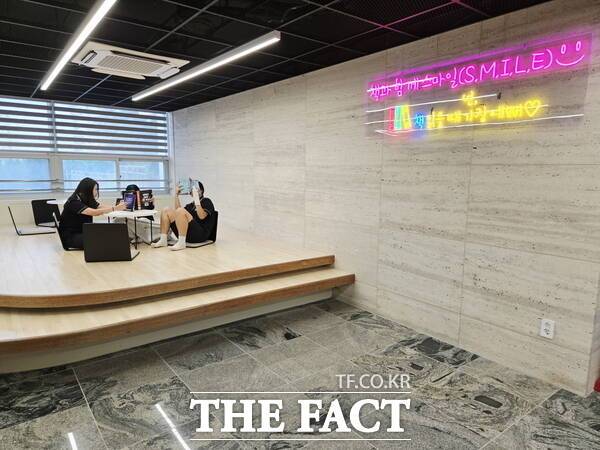 서향관(도서관) 마루에서 책과 함께 스마일(학교 독서 브랜드)하는 모습. /대전시교육청