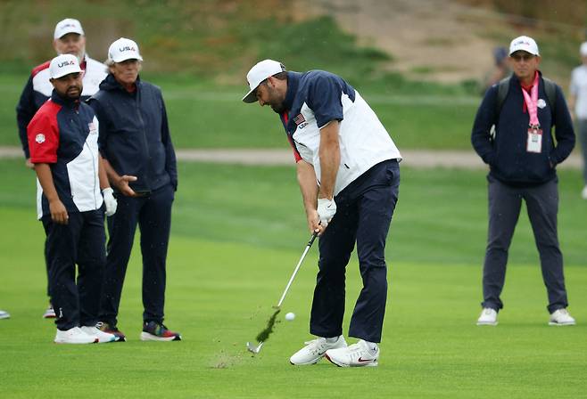 25일 미국 스코티 셰플러가 샷하는 모습을 동료와 스태프들이 보고 있다. /로이터 연합뉴스