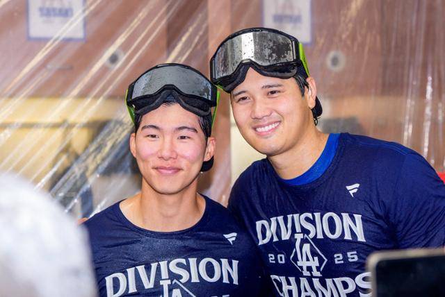 김혜성(왼쪽)과 오타니 쇼헤이가 26일 미국 애리조나주 피닉스 체이스필드에서 열린 애리조나와의 원정 경기에서 내셔널지구 서부지구 우승을 확정한 뒤 샴페인 파티 도중 기념사진을 찍고 있다. 피닉스=로이터 연합뉴스