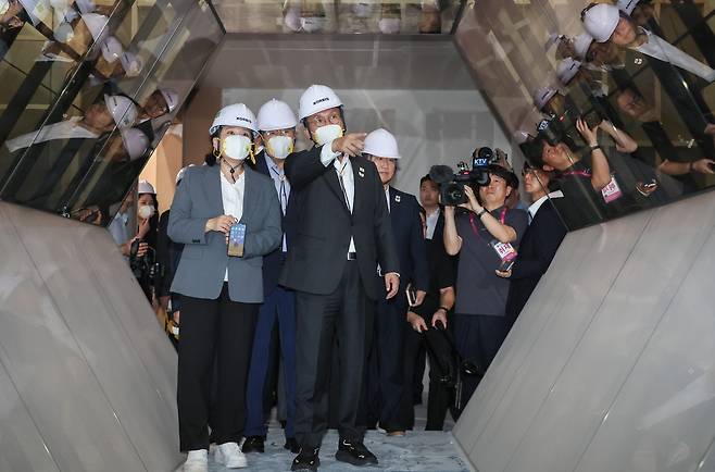 Prime Minister Kim Min-seok (center) surveys the interior of the APEC exhibition space in Gyeongju, North Gyeongsang Province, receiving a briefing on the installation progress as part of his on-site inspection. (Yonhap)