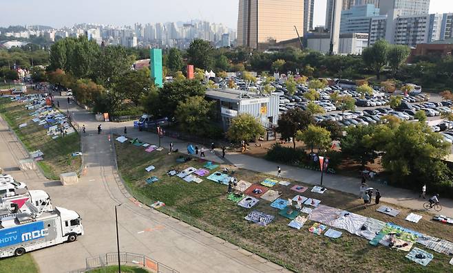 서울 여의도 한강공원 일대에서 열리는 ‘서울세계불꽃축제 2025’를 하루 앞둔 26일 행사장 주변에 시민들이 돗자리를 펴두고 자리를 선점하고 있다. [사진 = 연합뉴스]