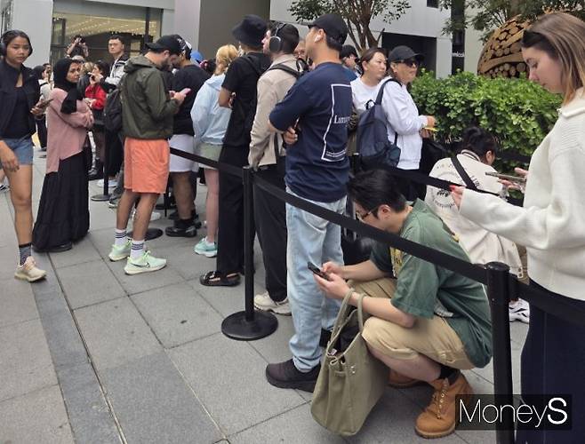 19일 오전 서울 중구 '애플 명동' 앞 거리에서 오랜 기다림에 지친 구매자들이 바닥에 앉아 휴식을 취하고 있다. /사진=김미현 기자