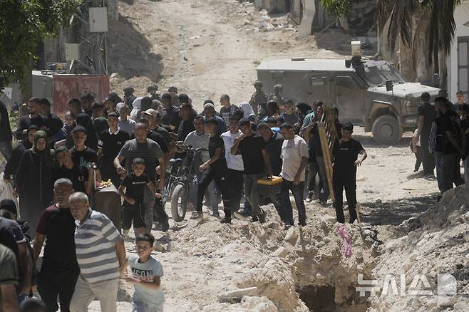 [툴카름=AP/뉴시스] 이스라엘 정부가 요르단강 서안지구 내에서 팔레스타인자치정부(PA)가 통제하는 지역은 합병할 계획 없다고 25일(현지 시간) 밝혔다. 사진은 지난 7월6일 서안지구 툴카름 난민촌에서 팔레스타인 주민들이 이스라엘 보안군의 주택 철거를 앞두고 소지품을 챙겨 집을 떠나는 모습. 2025.09.25.