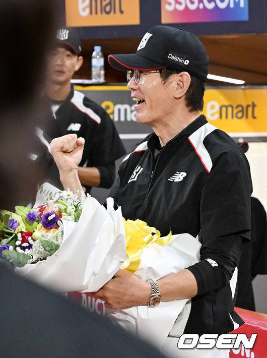 [OSEN=인천, 민경훈 기자] 25일 오후 인천 SSG랜더스필드에서 ‘2025 신한 SOL BANK KBO리그’ SSG 랜더스와 KT 위즈의 경기가 진행됐다.이 경기에서 KT는 SSG에 10-1 완승을 거두며 4연승을 질주했다. 3위 SSG를 잡은 5위 KT는 SSG를 1.5게임차로 맹추격했다. 4위 삼성도 키움전 승리를 거두면서 3위 경쟁은 결과를 예측할 수 없는 혼돈에 빠졌다.&nbsp;경기를 마치고 1000경기를 치른 KT 이강철 감독이 선수들에게 꽃다발을 받고 기뻐하고 있다.. 2025.09.25 / rumi@osen.co.kr