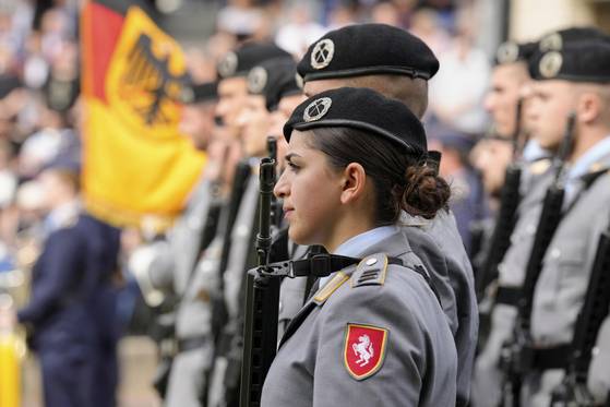 한 무장한 여군이 지난 4일(현지시간) 독일 뒤셀도르프의 노르트라인베스트팔렌 주 의회 앞에서 독일군 분데스베어 신병들이 선서식에 참석하는 모습을 지켜보고 있다. AP=연합뉴스