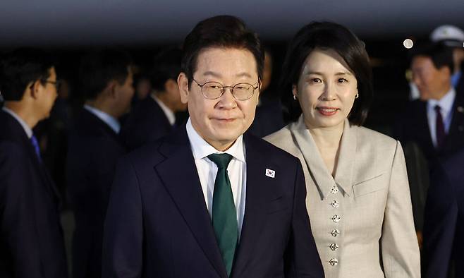 미국 방문 일정을 마치고 귀국한 이재명 대통령과 김혜경 여사가 26일 성남 서울공항에 착륙한 공군 1호기에서 내려 이동하고 있다. 연합뉴스