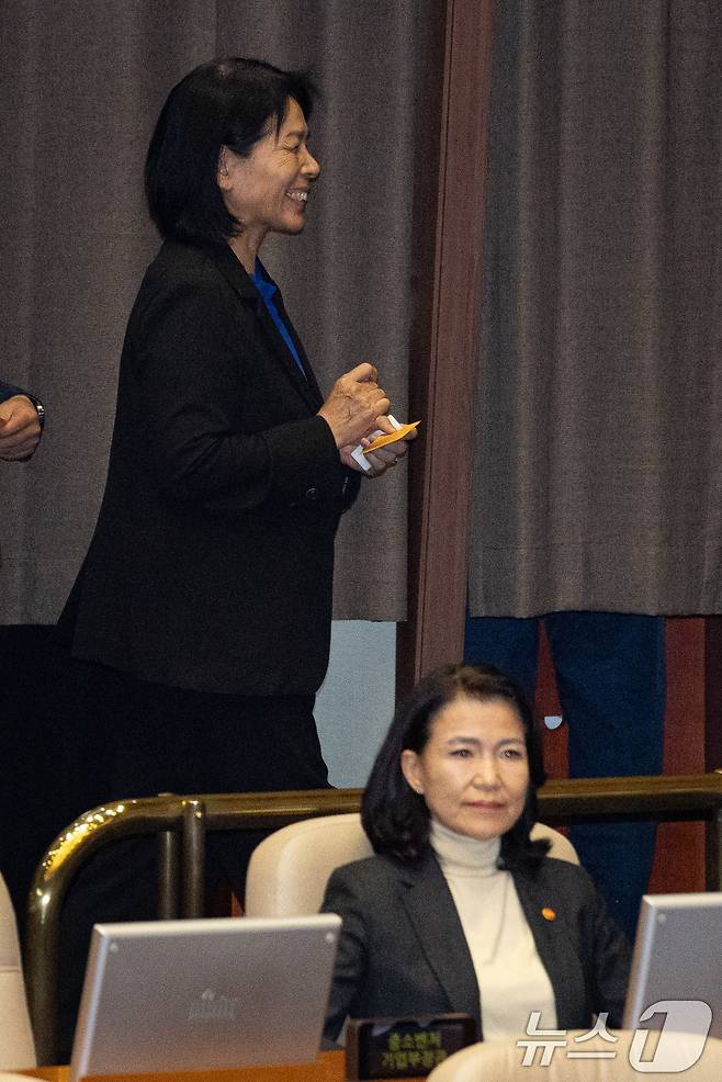 최민희 국회 과학기술정보방송통신위원장이 27일 서울 여의도 국회에서 열린 제429회 국회(정기회) 제9차 본회의에서 방송미디어통신위원회의 설치 및 운영에 관한 법률안(대안)에 대한 무제한토론(필리버스터) 종결동의의 건 투표를 마친 후 미소 지으며 이진숙 방송통신위원장 뒤를 지나고 있다. 2025.9.27/뉴스1 ⓒ News1 유승관 기자