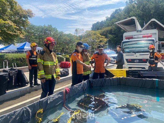 지난 27일 김승룡 소방청장 직무대행이(왼쪽 세번째) 국가정보자원관리원 화재 현장에서 소화수조에 담긴 불에 탄 리튬이온 배터리를 살펴보고 있다. ⓒ소방청
