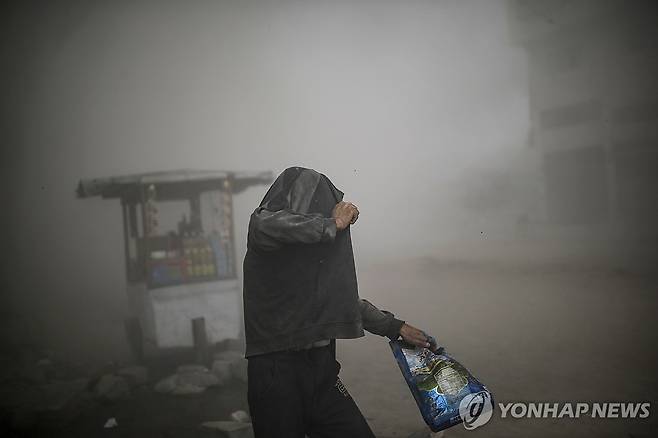 27일(현지시간) 가자시티에서 이스라엘군의 공습 직후 옷으로 몸을 가리는 팔레스타인 주민  [EPA 연합뉴스]
