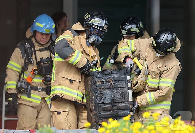 27일 오후 대전 유성구 국가정보자원관리원 화재현장에서 소방당국 관계자들이 소실된 리튬이온배터리에 대한 반출 작업을 하고 있다. 전산 자원을 통합 관리하는 행정안전부 산하 국가정보자원관리원에서 지난 26일 오후 배터리 교체 작업 중 화재가 발생, 정부 온라인 서비스 70개가 마비됐다. 2025.9.27/뉴스1 ⓒ News1 김진환 기자