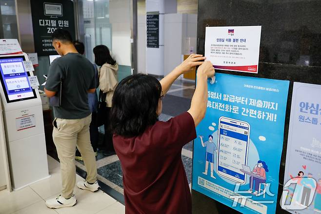 정부가 대전 국가정보자원관리원(국정자원) 전산실에서 발생한 화재로 중단된 행정정보시스템 복구에 총력을 기울이고 있는 29일 오전 서울 종로구청에서 직원이 민원실 이용 불편 안내문을 부착하고 있다. 2025.9.29/뉴스1 ⓒ News1 안은나 기자