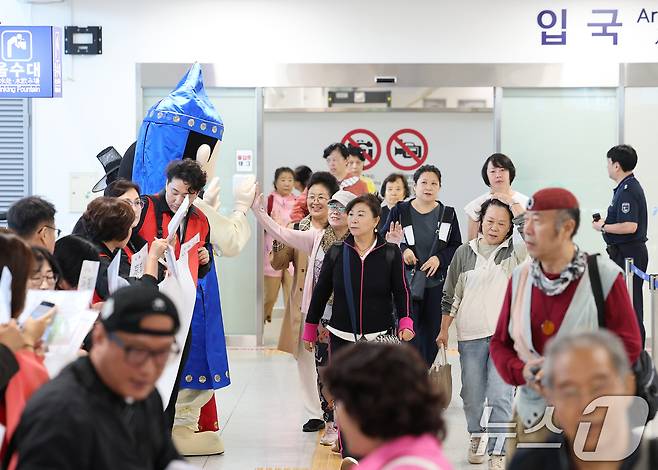 중국 단체관광객의 무비자 입국이 시작된 29일 오전 크루즈를 타고 방한한 중국인 관광객들이 인천 연수구 인천항크루즈터미널을 통해 입국하며 손을 흔들고 있다.  2025.9.29/뉴스1 ⓒ News1 오대일 기자