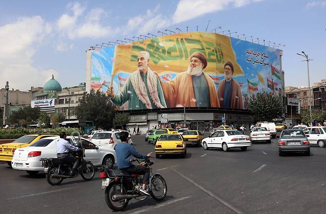 이란 테헤란 시내에 걸린 카셈 솔레이마니(왼쪽), 하산 나스랄라(가운데), 세이크 사피에딘(오른쪽) 등 친이란 지도자들의 대형 광고판 앞을 차량들이 지나가고 있다. 솔레이마니는 이란 혁명수비대 쿠드스군 사령관으로 2020년 미군 드론 공습으로 사망했고, 나스랄라와 사피에딘은 각각 올해 7월과 9월 이스라엘군 공습으로 숨진 레바논 헤즈볼라 지도자들이다. 이란은 27일 영·프·독이 유엔 대(對)이란 제재 복원을 위한 ‘스냅백’ 절차를 발동한데 반발해 세 나라 주재 자국 대사를 긴급 소환했다. /EPA 연합뉴스