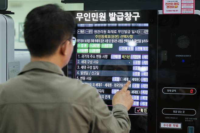 정부가 대전 국가정보자원관리원(국정자원) 전산실에서 발생한 화재로 중단된 행정정보시스템 복구에 총력을 기울이고 있는 29일 오전 서울 종로구청에서 이용이 중단됐던 무인민원발급기가 복구돼 직원이 주민등록등본 발급을 시연하고 있다. /뉴스1