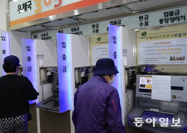 28일 광주 광산구 광산우체국을 찾은 시민들이 ATM에 붙은 서비스 이용 중지 안내문을 살펴보고 있다. 광주=박영철 기자 skyblue@donga.com