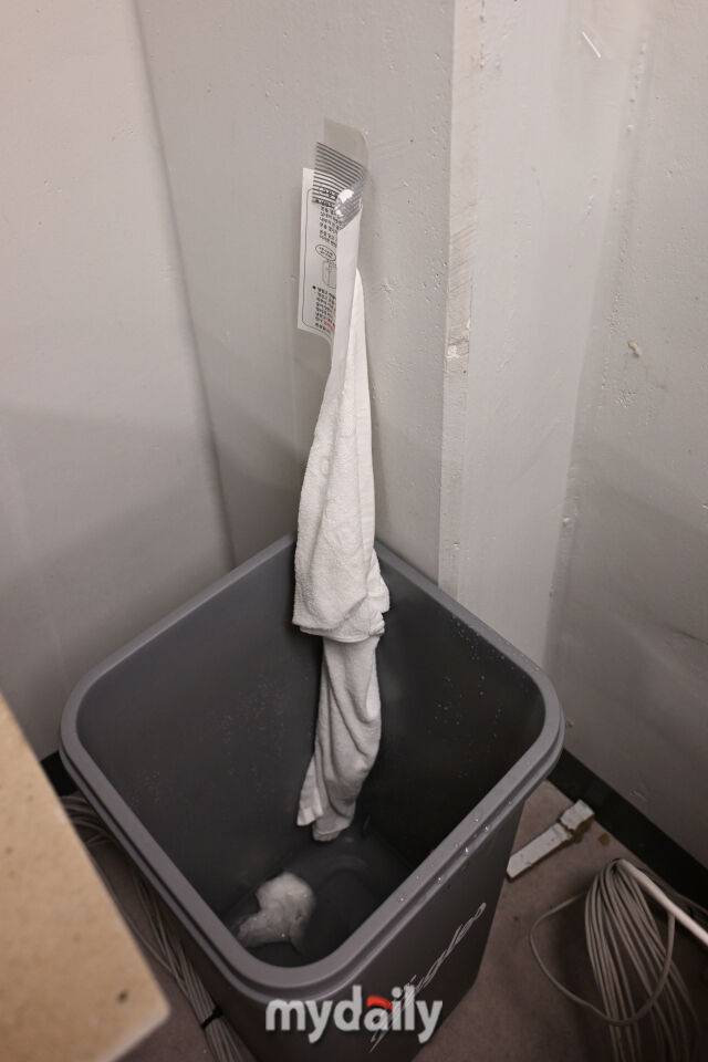 ▲ 벽을 타고 내리는 빗물을 쓰레기통을 이용해 받아내고 있다.