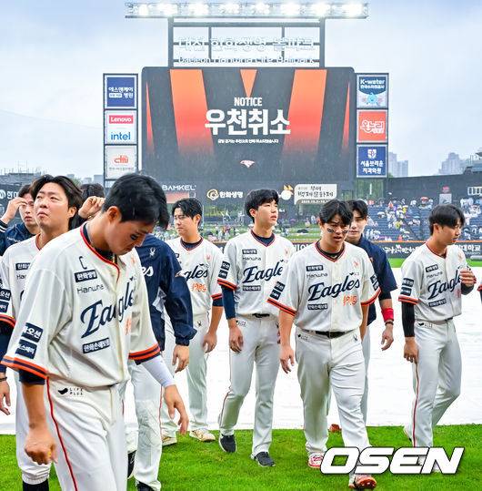 [OSEN=대전, 민경훈 기자] 프로야구 LG 트윈스의 정규리그 우승 확정이 비로 인해 미뤄졌다. 1시간 지연 시작 목표로 그라운드를 정비했으나, 오락가락하는 비 때문에 방수포를 걷었다가 다시 깔면서 대기 시간이 길어지자 결국 우천 취소 결정이 났다. 28일 오후 2시 대전 한화생명볼파크에서 열릴 예정이었던 2025 신한 SOL Bank KBO리그 LG 트윈스와 한화 이글스의 시즌 16차전 마지막 대결이 우천 취소됐다. 전광판에 우천취소 문구가 뜨며 한화 선수들이 퇴장하고 있다. 2025.09.28 / rumi@osen.co.kr
