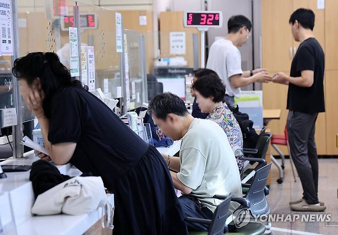 국정자원 화재로 국가전산망 먹통 나흘째 (서울=연합뉴스) 윤동진 기자 = 국가정보자원관리원(국정자원) 대전 본원 화재로 전산망 마비 사태가 나흘째 이어지는 29일 서울의 한 주민센터에서 시민들이 업무를 보고 있다. 2025.9.29 mon@yna.co.kr