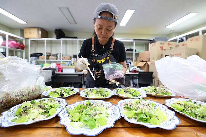 김주휘씨가 지난 22일 구미 한국옵티칼하이테크 농성장에서 샐러드 위에 블루베리를 올리고 있다. 정효진 기자