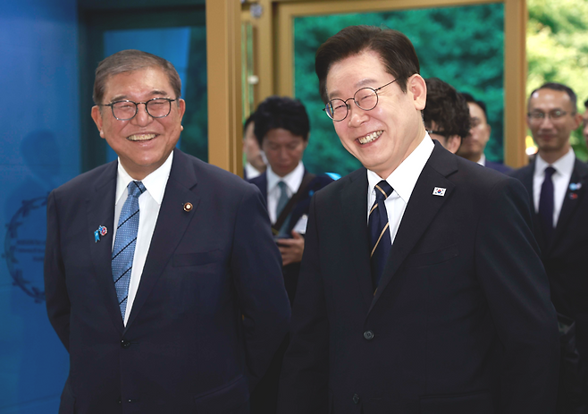 President Lee Jae Myung (right, front) and Japanese Prime Minister Shigeru Ishiba (left, front) enter the Nurimaru APEC House in Busan, where they held their third adn final summit on Tuesday. (Pool photo via Yonhap)