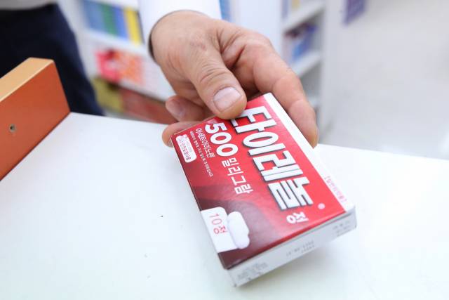 약국에서 약사가 타이레놀을 집어 들고 있다. 연합뉴스