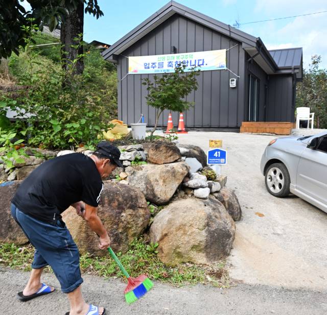 산청군 시천면 외공마을에서 산불로 주택을 잃은 한 주민이 새 집 입주를 앞두고 주변 청소를 하고 있다./김승권 기자/