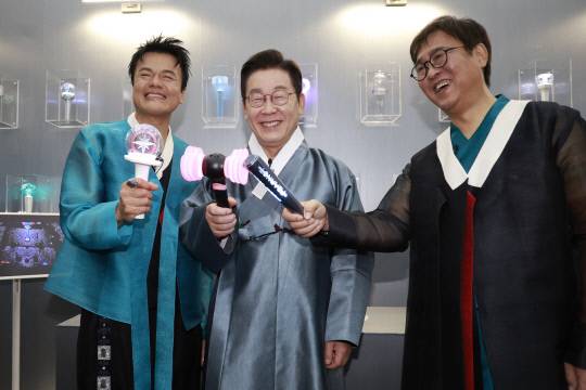 이재명 대통령(가운데)이 1일 경기 고양시 킨텍스에서 열린 대중문화교류위원회 출범식에서 박진영(왼쪽)·최휘영 대중문화교류위원회 공동위원장과 K컬처 체험존에서 응원봉을 들고 기념촬영을 하고 있다. 연합뉴스
