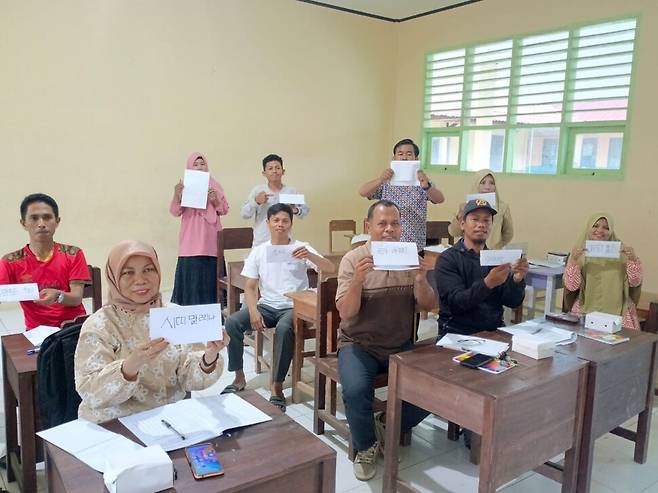 인도네시아 찌아찌아족 한글 교사 양성을 위한 연수에 참여한 현지인들이 자신들의 이름을 찌아찌아 한글로 써서 들고 기념사진을 찍고 있다. 우충환 제공