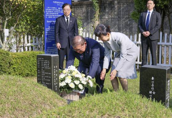 Japanese Prime Minister Shigeru Ishiba and first lady Yoshiko Ishiba pay respects to Lee Soo-hyun, a Korean student who lost his life trying to save a Japanese man at a subway station in Tokyo in 2001, at a cemetery in Busan ahead of a summit with President Lee Jae Myung on Sept. 30. [YONHAP]