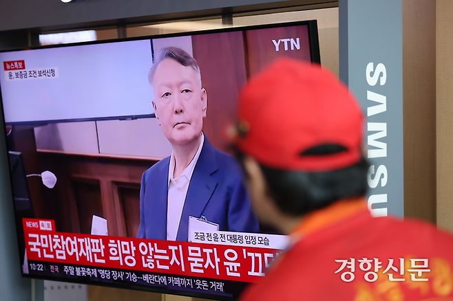 한 시민이 지난달 26일 서울역 대합실에서 윤석열 전 대통령의 ‘체포 방해’ 혐의 첫 재판을 시청하고 있다. 성동훈 기자