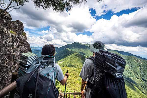 연석산에서 하산해 운장산으로 넘어가는 길. 나무 데크 계단을 따라 걸어내려간다. 멀리 운장산 서봉의 암부가 보인다.
