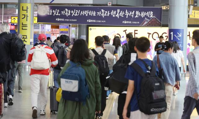 추석 연휴를 하루 앞둔 2일 오후 부산 동구 부산역에서 일찍 귀성하는 시민들 위쪽 벽면에 행복한 추석 명절을 기원하는 펼침막이 내걸려 있다. 연합뉴스