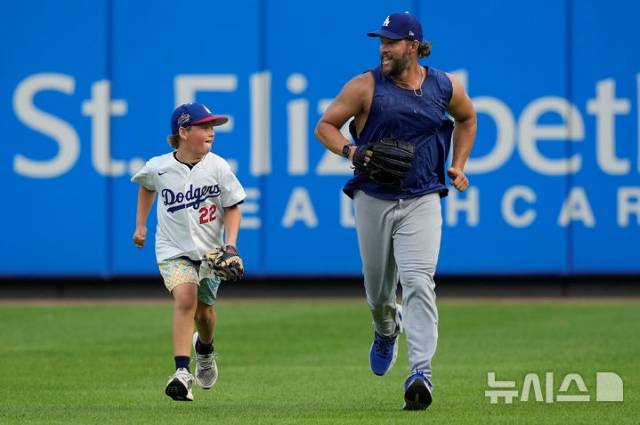 지난 28일(현지 시간) 신시내티 레즈와의 원정경기에 앞서 앞서 아들 찰리와 경기장을 달리고 있는 커쇼. 커쇼는 은퇴 후 계획에 대해 "다섯 아이들과 시간을 보내느라 바쁠 것"이라고 말했다. / AP 뉴시스