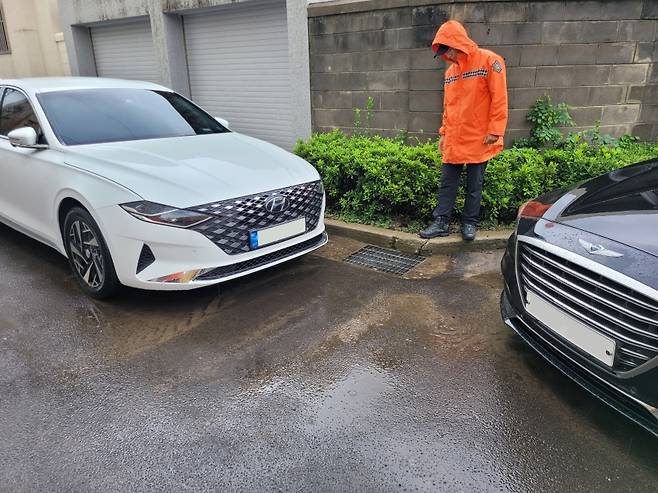 제주시 연동 골목에서 소방대원이 역류한 배수구를 점검하고 있다. (제주도소방안전본부 제공)