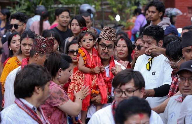 아버지에게 안겨 사원으로 떠나는 아리아타라 샤카 [AP뉴스]