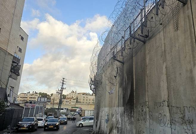 생존의 통로 (라말라[요르단강서안]=연합뉴스) 김동호 특파원 = 1일(현지시간) 요르단강 서안 카프르아카브 마을의 분리장벽 일부 구간의 철조방이 뜯어져 늘어진 모습. 2025.10.2 dk@yna.co.kr